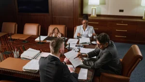 Marine law firm consultants meeting with clients in a modern office, reviewing maritime case files