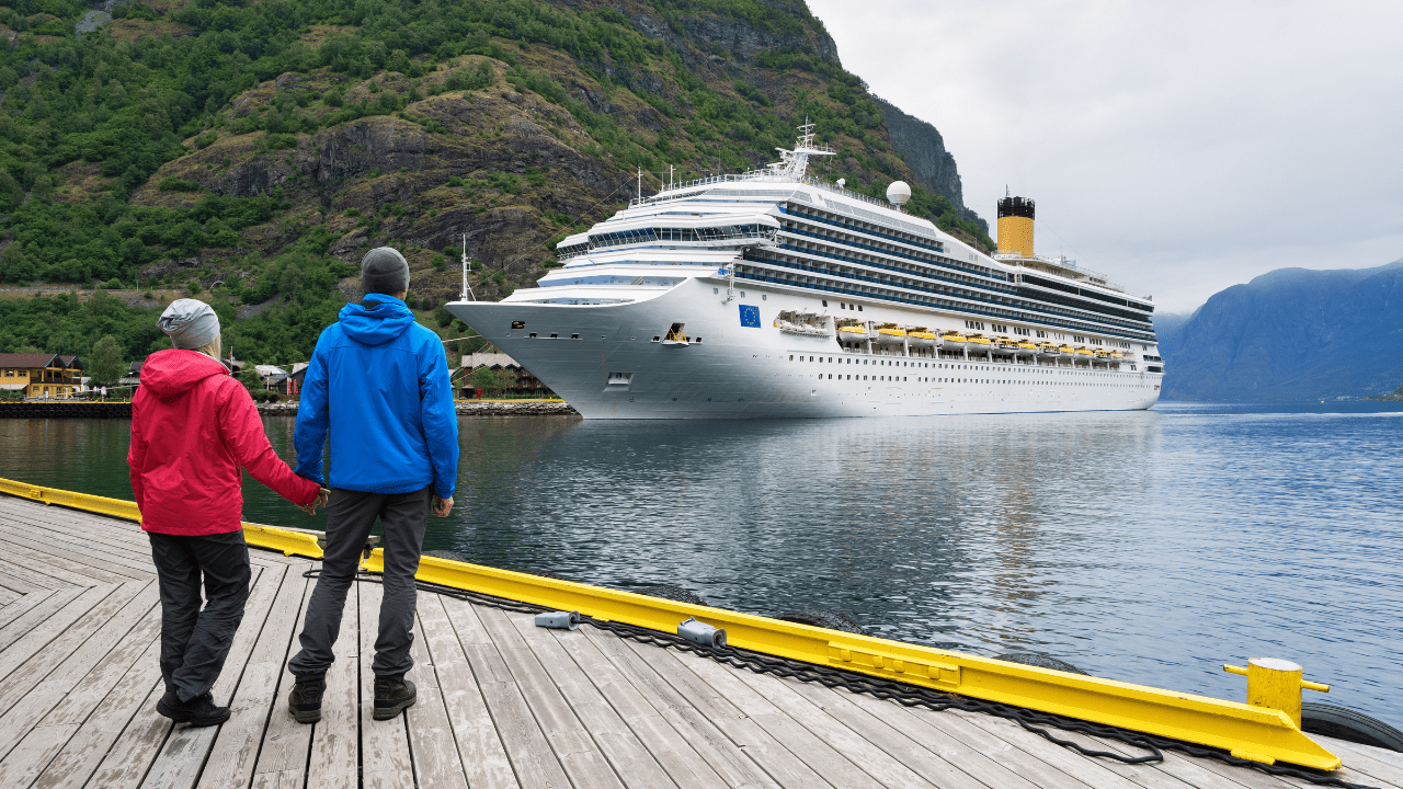 Cruise ship docked at port with passengers disembarking